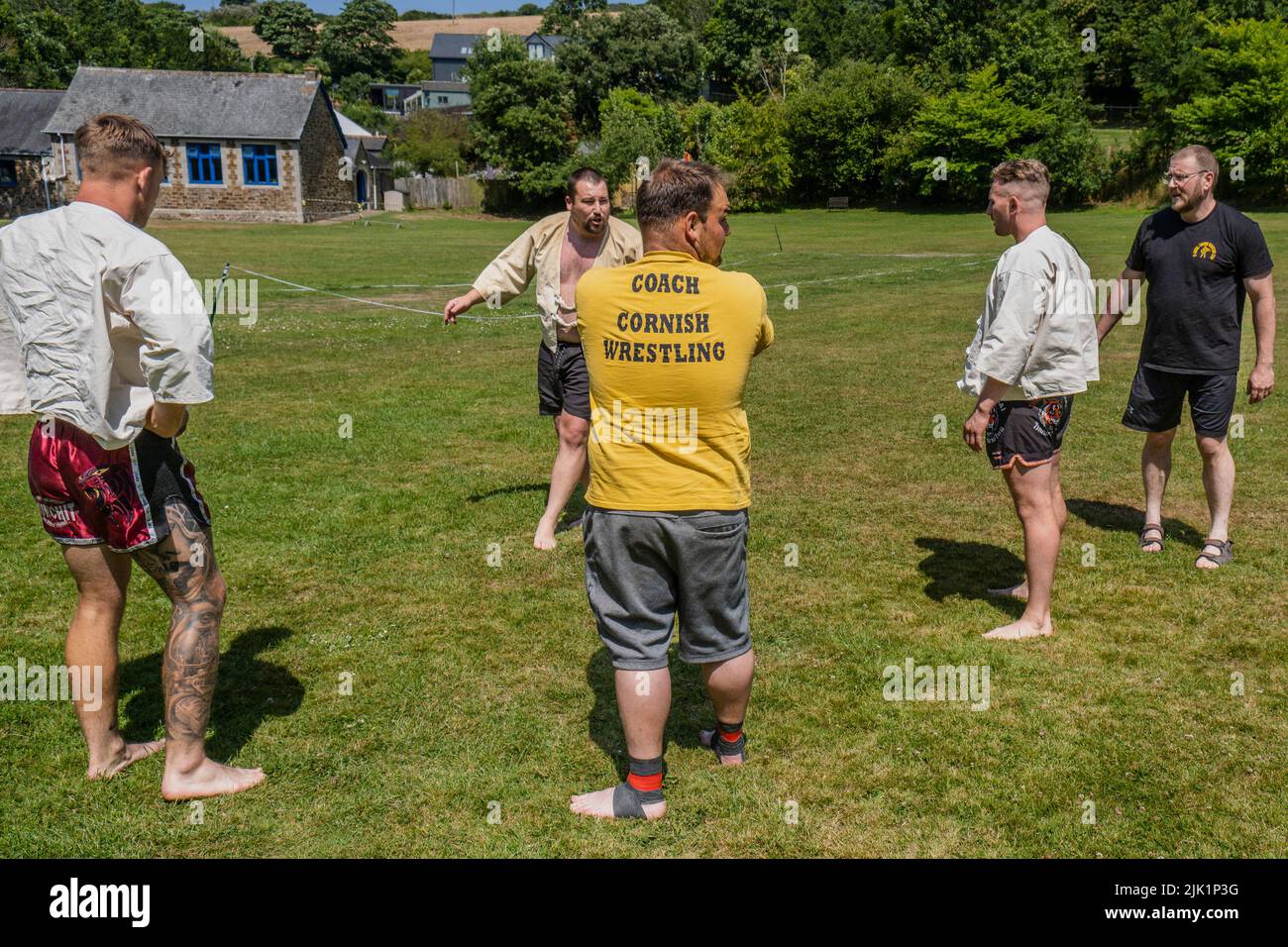 Coaches teaching the rules and techniques of Cornish Wrestling before the start of the Grand Cornish Wrestling Tournament on the picturesque village g Stock Photo