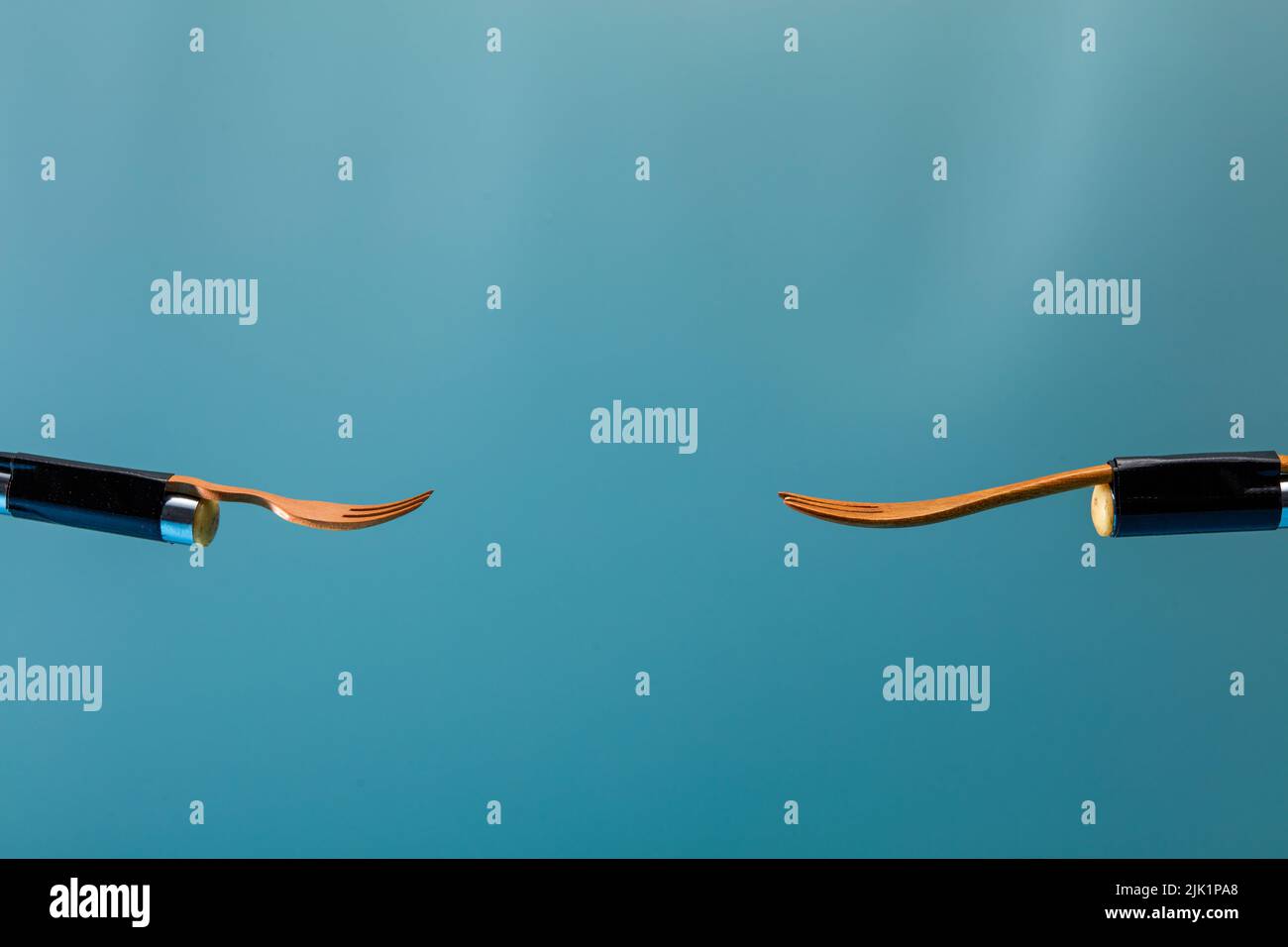 Two forks in front of a blue background Stock Photo Alamy