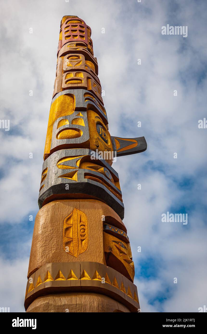 Isolated totem wood pole in blue sky background. Indian totem poles in park in Nanaimo, Canada. Travel photo, copy space for text, nobody Stock Photo
