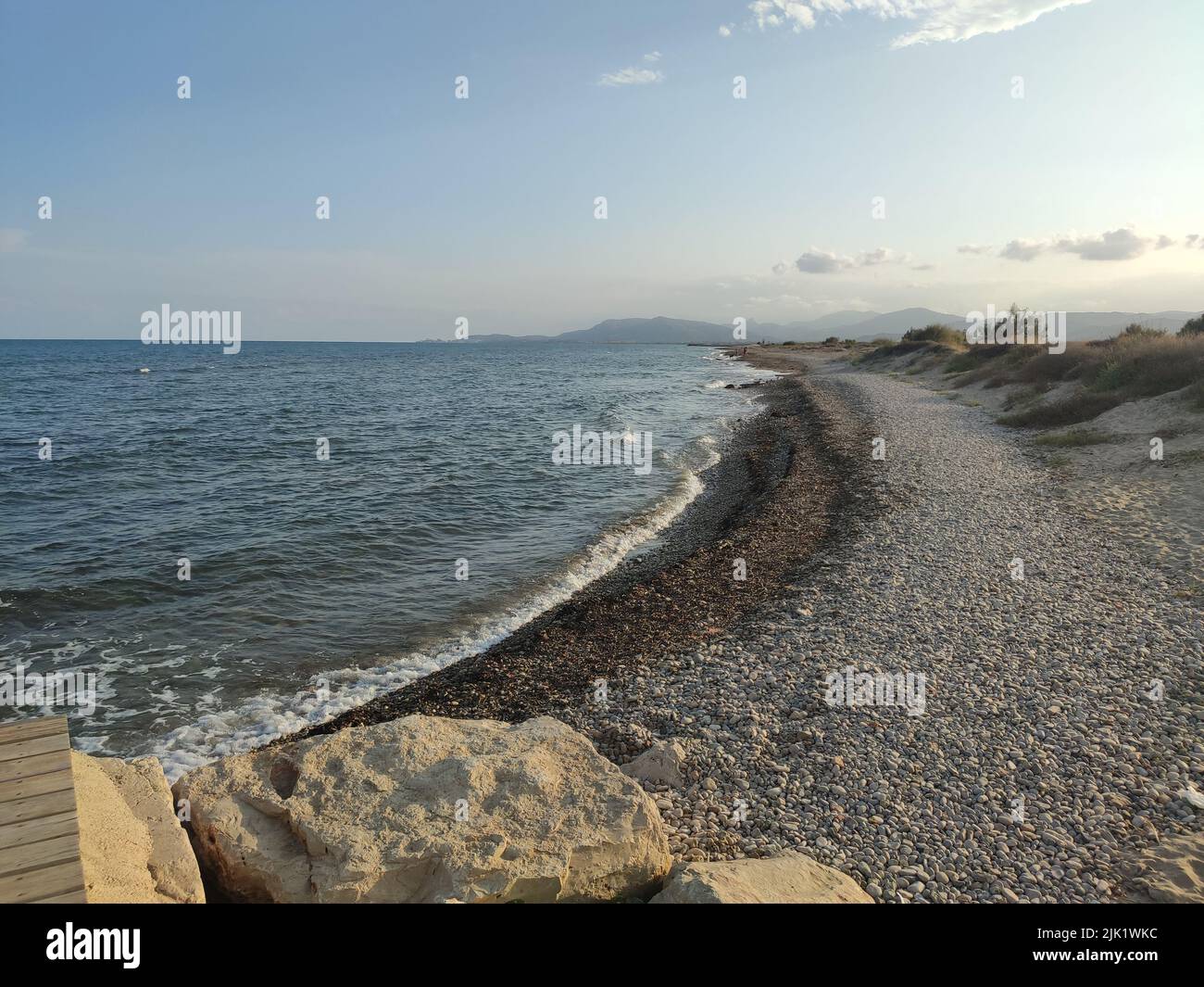 Beach. Rocky beach empty of people. Cozy and calm image next to the Mediterranean Sea and the waves breaking on the shore. In Spain. Europe. Horizonta Stock Photo
