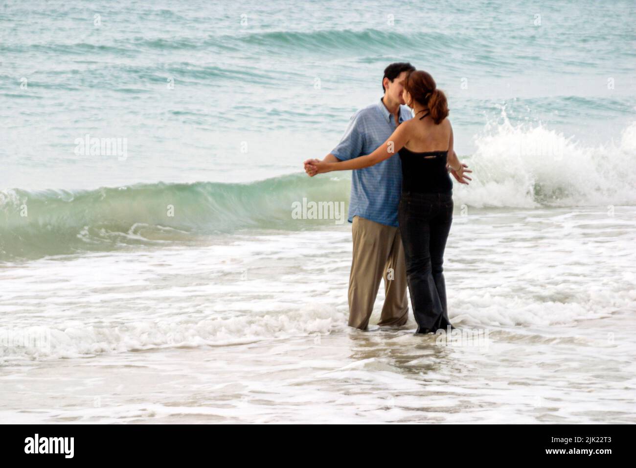 Miami Beach Florida,Atlantic Ocean Shore shoreline coast coastline seashore,young romantic couple adult adults man woman surf hugging kissing Stock Photo