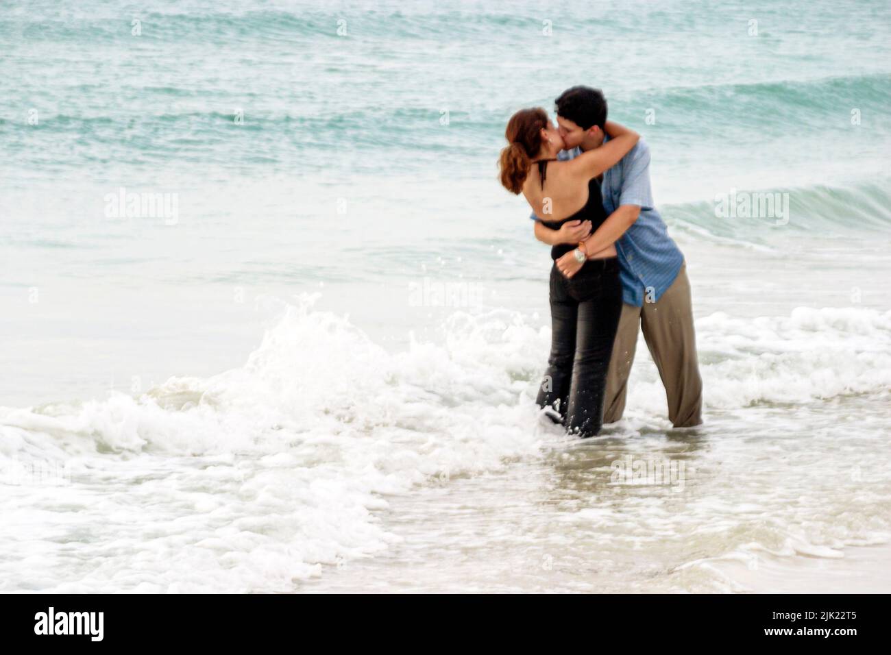 Miami Beach Florida,Atlantic Ocean Shore shoreline coast coastline seashore,young romantic couple adult adults man woman surf hugging kissing Stock Photo