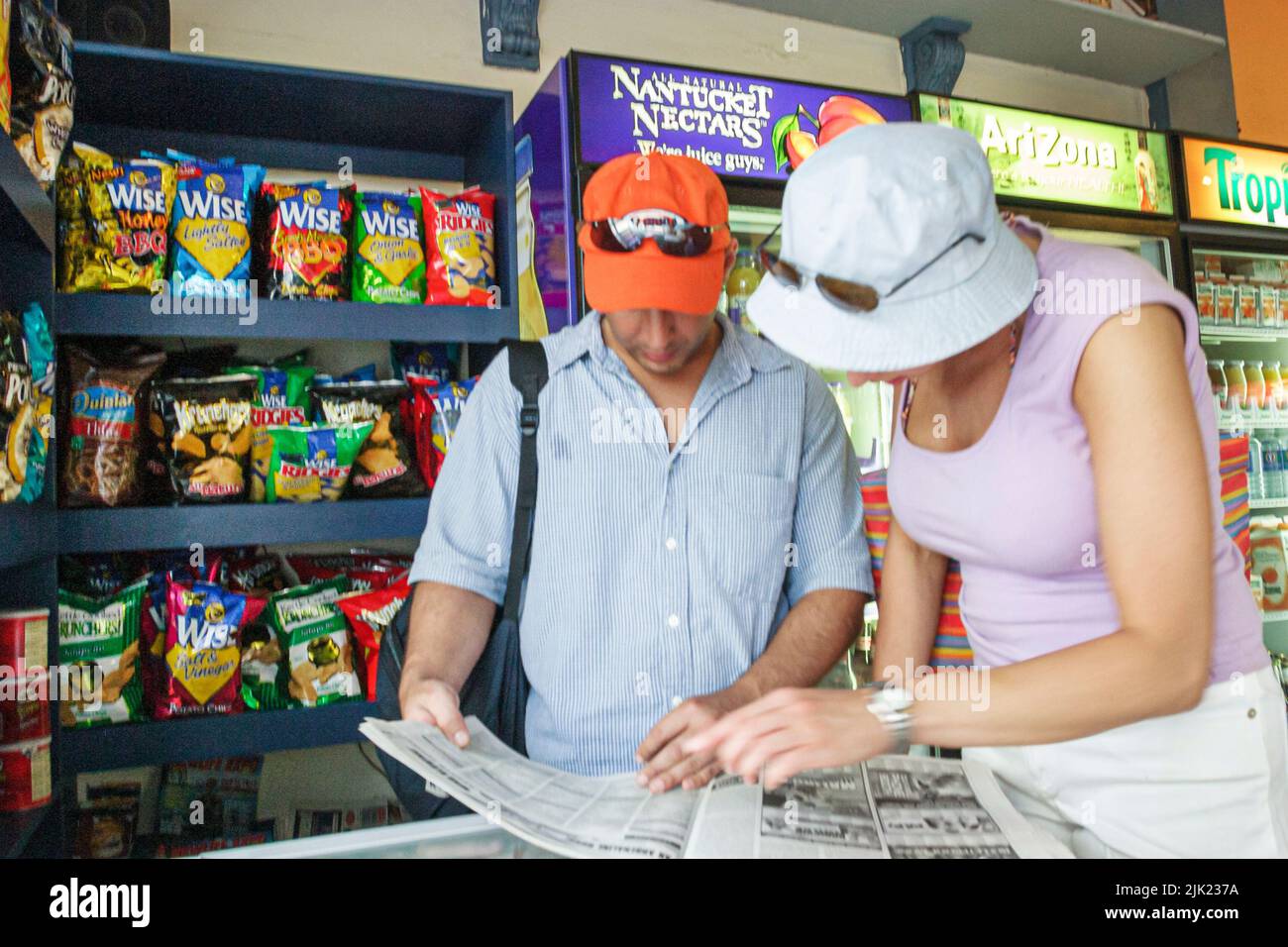 Miami Beach Florida,South Beach,Ocean Drive,inside interior convenience store,tourist couple,adult adults man men male,woman,looking local newspaper Stock Photo