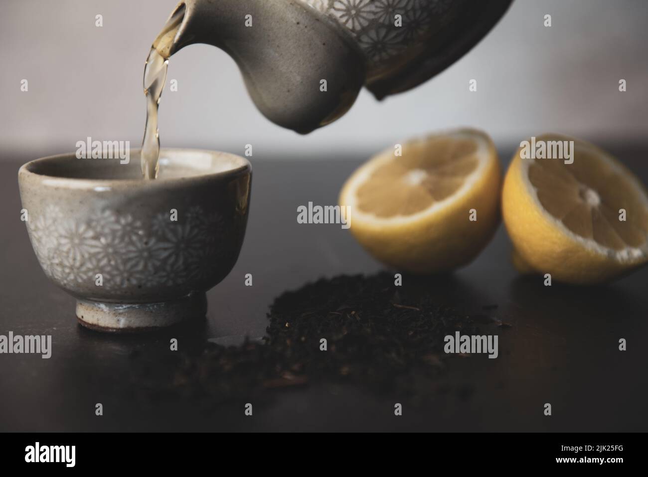 Pouring Korean tea into teacups with lemon and loose leaf tea Stock