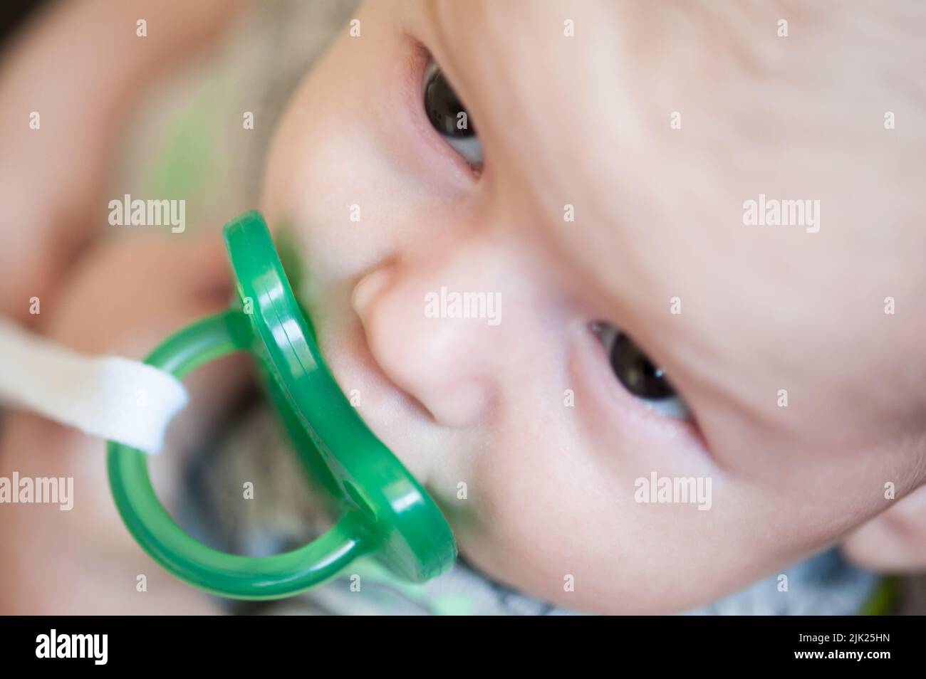 Close-up detail view of cute little peaceful baby with pacifier in his ...
