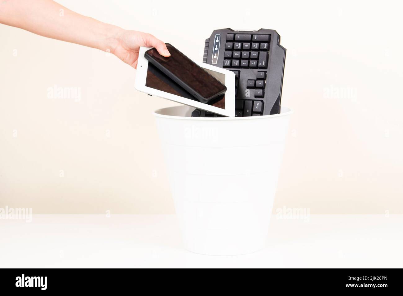 Female hand puts used digital tablet computer and cell phones into