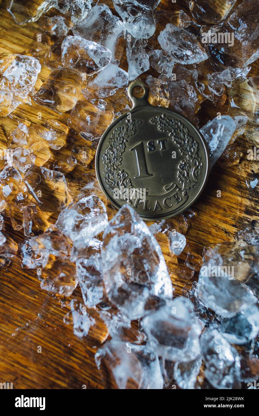 first place gold winning medal on ice against wood / crushing it Stock Photo