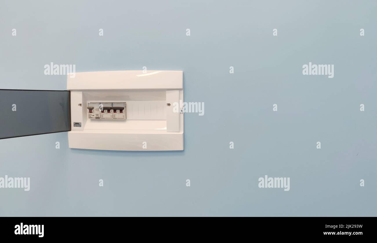 Circuit breaker board displays many switches. A finger is about to turn