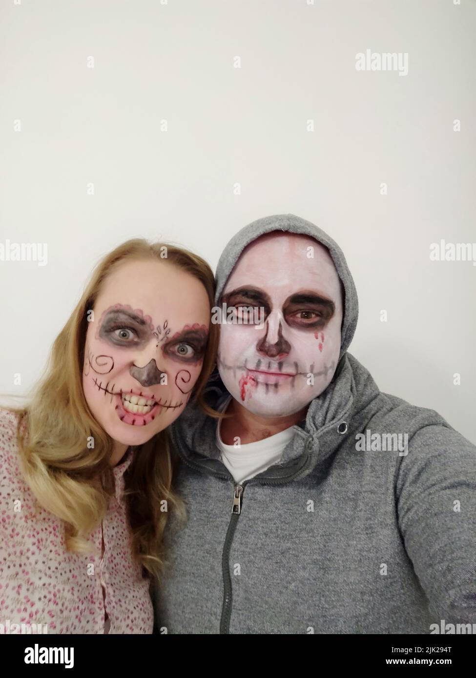 Young people with a painted skull on their face on a white background. Celebration of the Day of the Dead Stock Photo