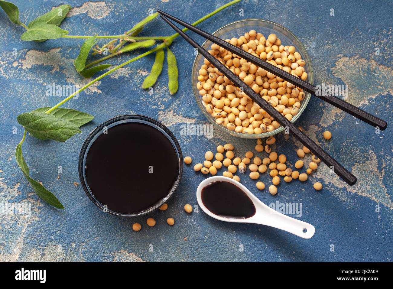 Organic, domestic soy beans and soy sauce in a glass bowl with leaves
