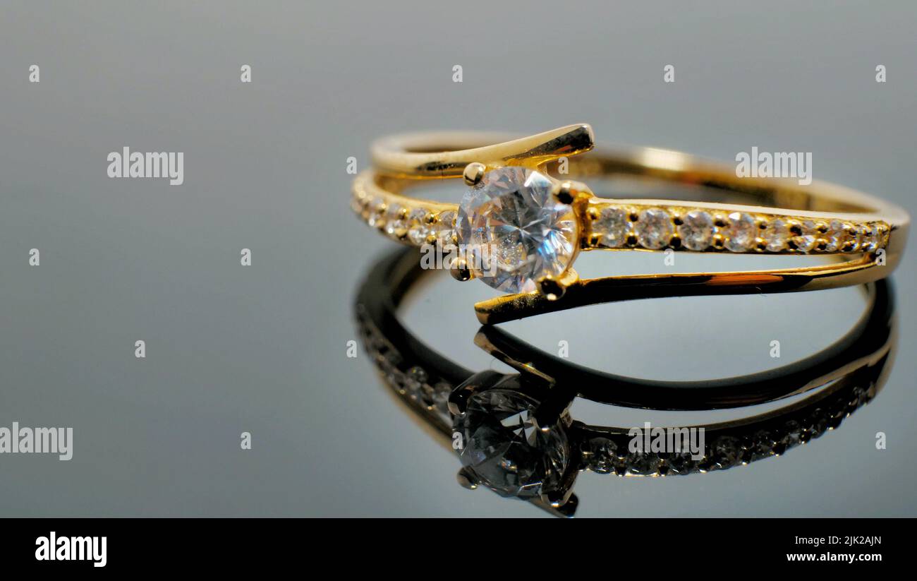 Gold jewelry ring with diamond on reflected black table Stock Photo