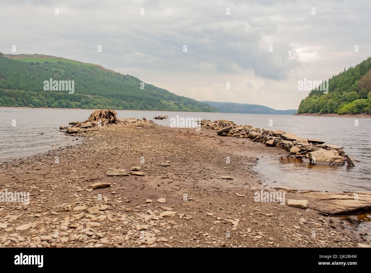 Receding waters at Lake Vyrwny, after a dry summer so far of 2022. You can just start to make out some old buildings that where submerged. Stock Photo