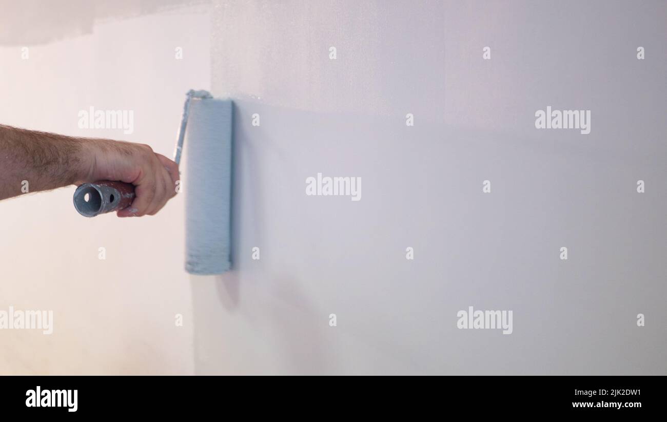 Decorators hand painting wall with roller Stock Photo Alamy