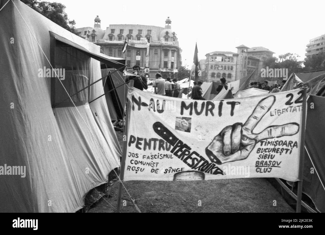 Bucharest, Romania, May 1990. 'Golaniada', a major anti-communism protest  in the University Square following the Romanian Revolution of 1989. People would gather daily to protest the ex-communists that took the power after the Revolution. The main demand was that no former party member would be allowed to run in the elections of May 20th. In this picture, taken in the days following the elections, people are literally camping in the square in protest of the 'rigged' elections. A banner says 'They did not died for Perestroika'. Stock Photo