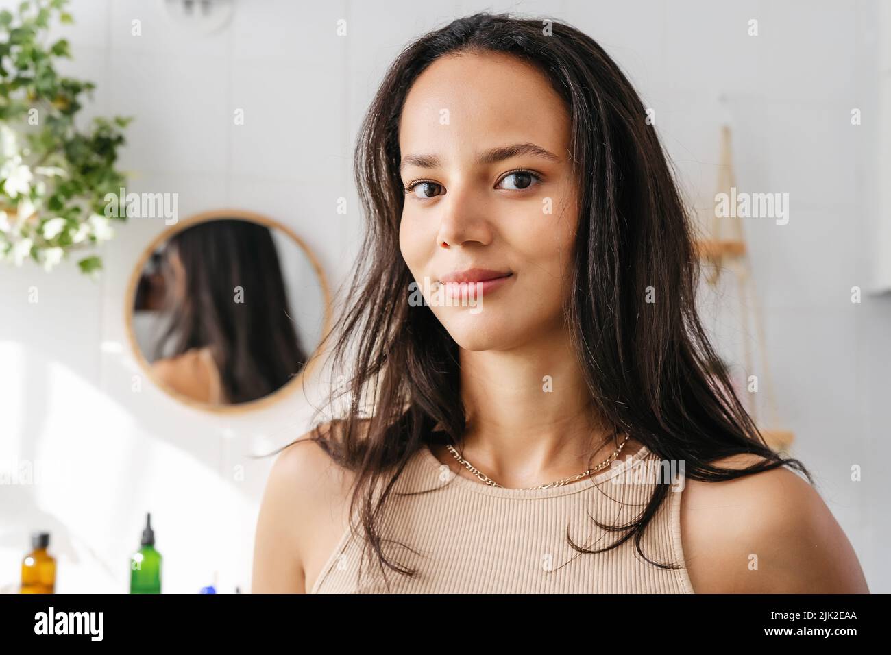 Close up beauty portrait of hispanic woman in bathroom. Confident young woman feeling positive and comfortable in her body. Woman's power. Wellness Stock Photo