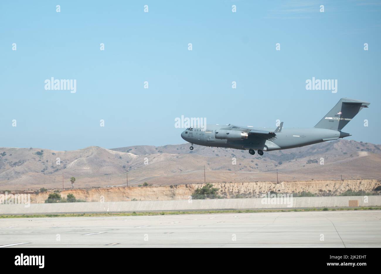 A U.S. Air Force C-17 Globemaster III aircraft with 21st Airlift Squadron, 60th Air Mobility Wing, Travis Air Force Base, California prepares to land on Marine Corps Air Station Camp Pendleton, California, during a joint training exercise, July 25, 2022. This exercise included aircraft from five different Air Force squadrons and U.S. Marines with 3rd Battalion, 5th Marine Regiment, 1st Marine Division to enhance their expeditionary operations in a joint-training environment. This was the first time MCAS Camp Pendleton staged five Globemaster III aircraft on the air station at the same time. (U Stock Photo