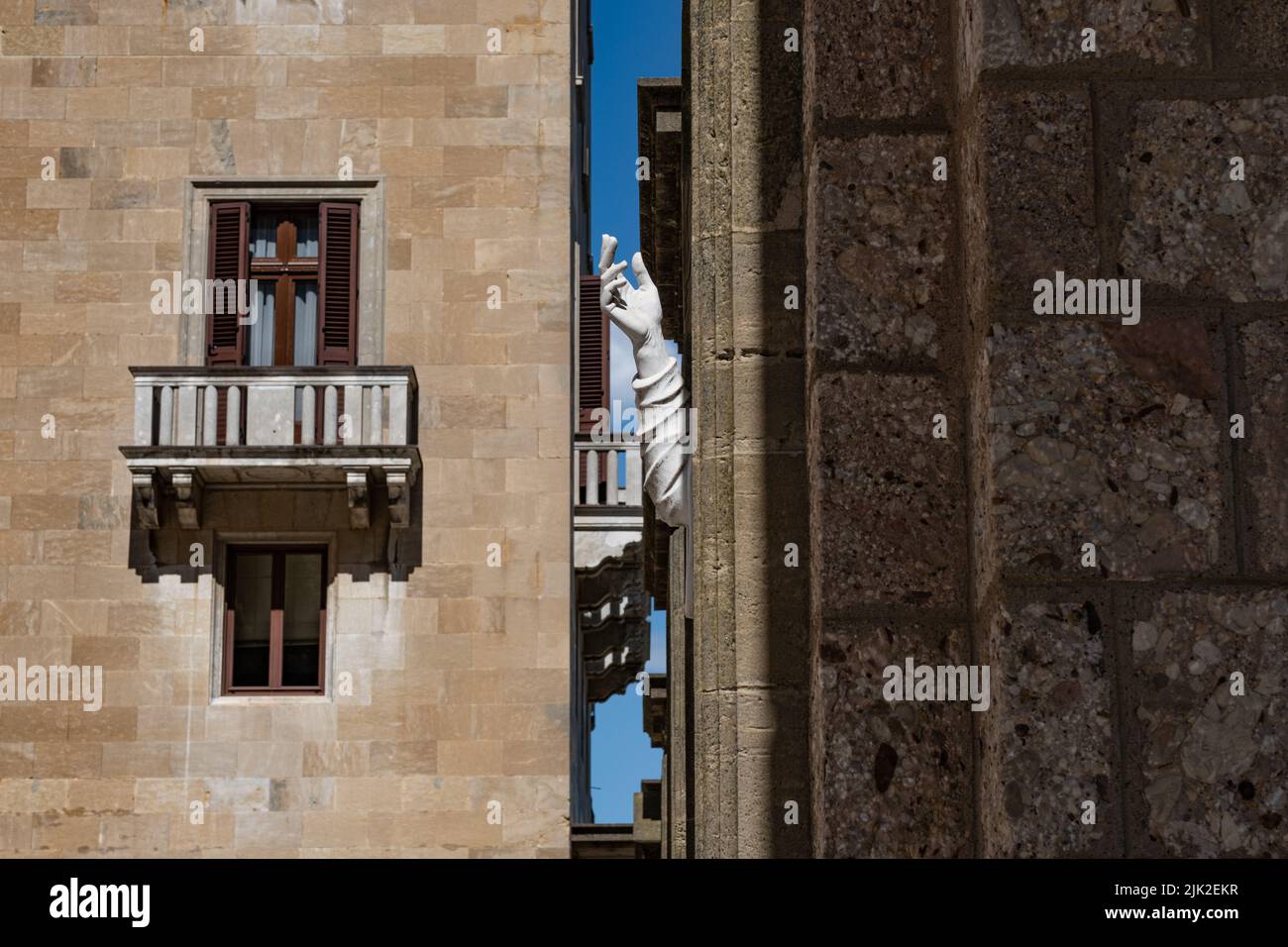 Close-up side view of the arm of a white marble statue placed in the outdoor courtyard of the religious complex of Montserrat, near Barcelona, Spain. Stock Photo