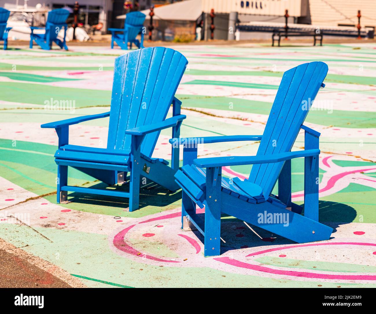 Two wooden adirondack chairs. Blue adirondack chairs on the street