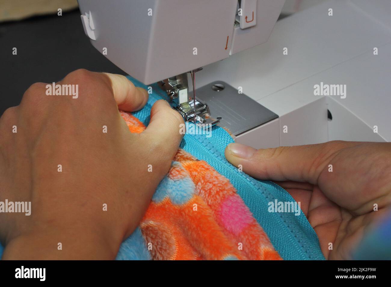 female hands sew on a sewing machine Stock Photo