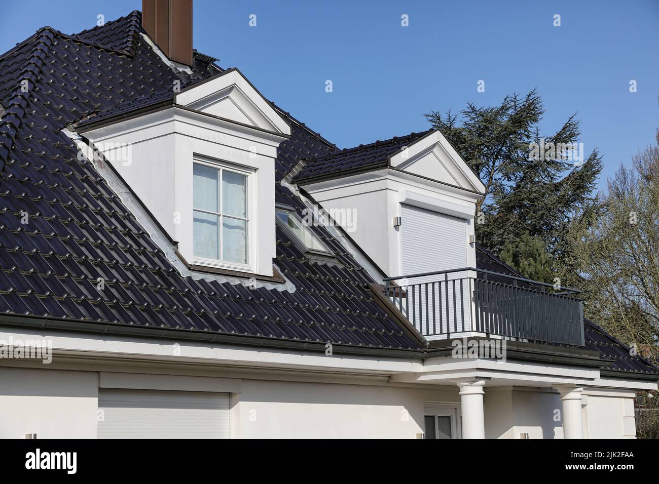 detached house with gabled dormers on black roof Stock Photo