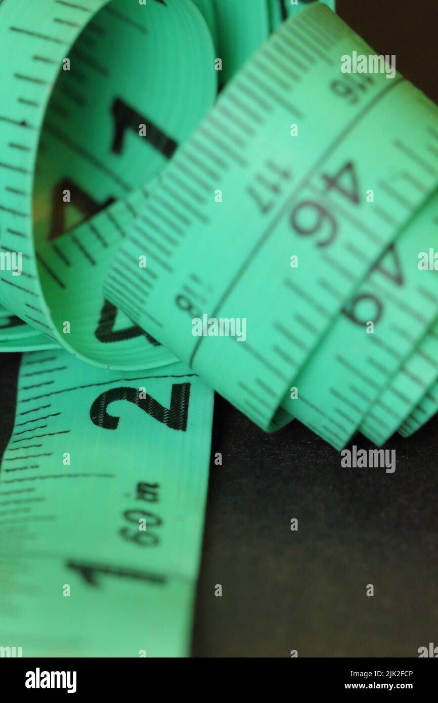 Green tailor's tape measure in centimeters and inches Stock Photo