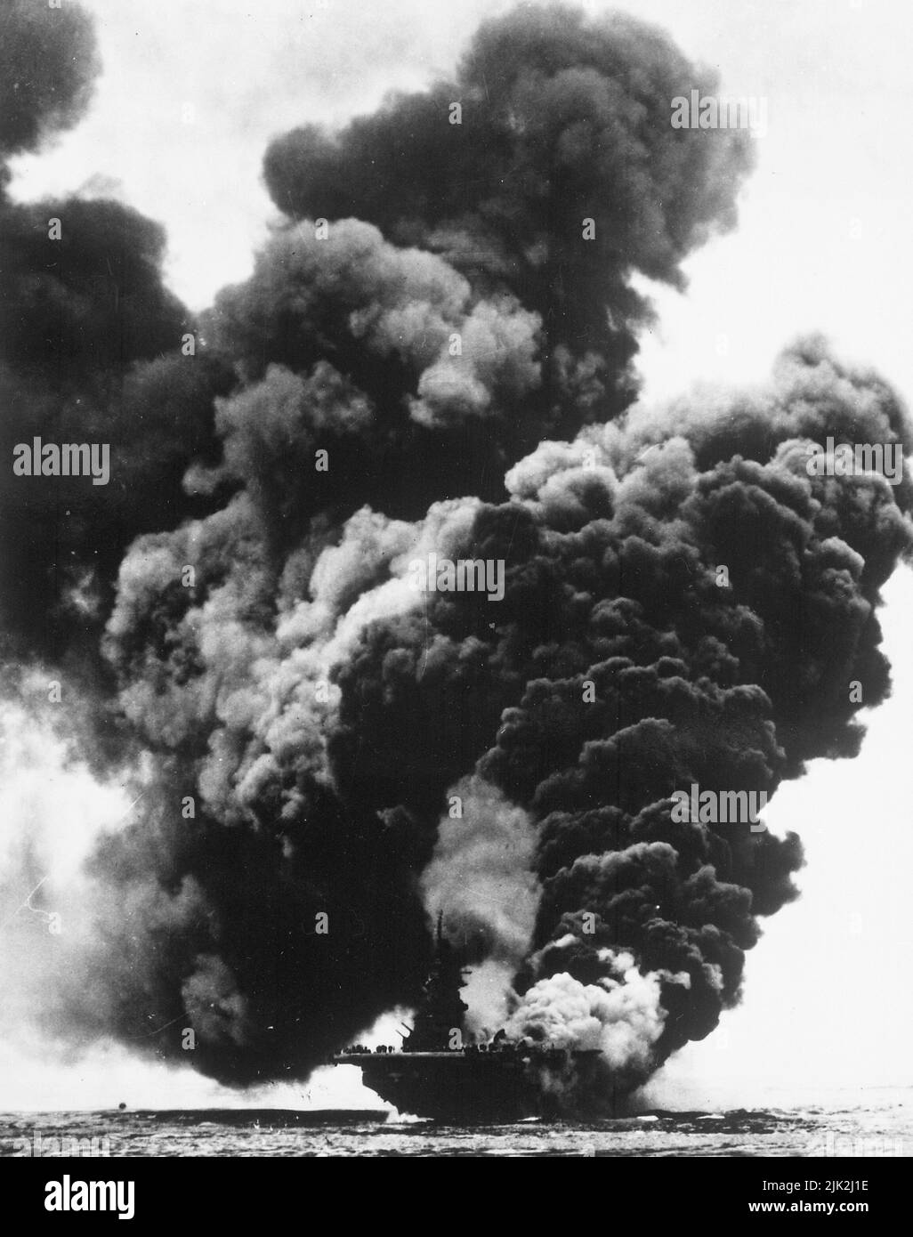 USS Bunker Hill burning after a Japanese kamikaze attack. Near Okinawa, May 11, 1945. Stock Photo