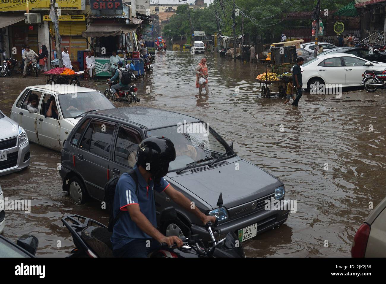 Lahore, Pakistan. 29th July, 2022. Pakistani people wade through a