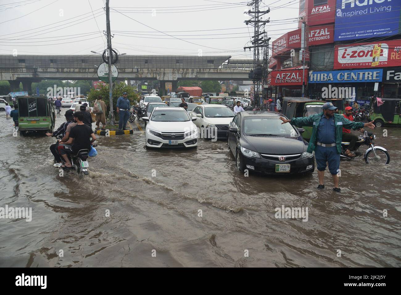 Lahore, Pakistan. 29th July, 2022. Pakistani people wade through a