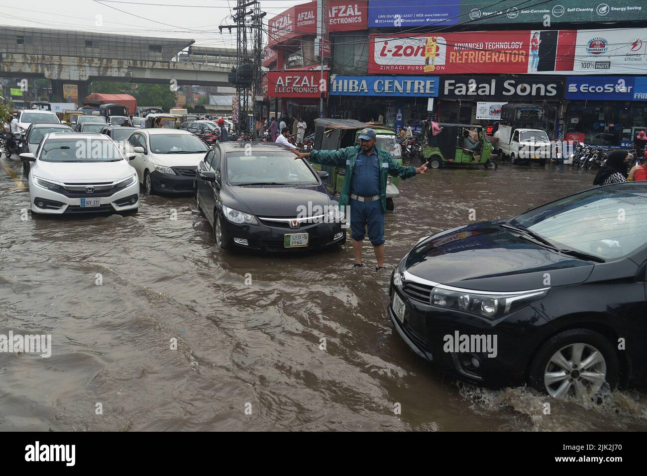 Lahore, Pakistan. 29th July, 2022. Pakistani people wade through a
