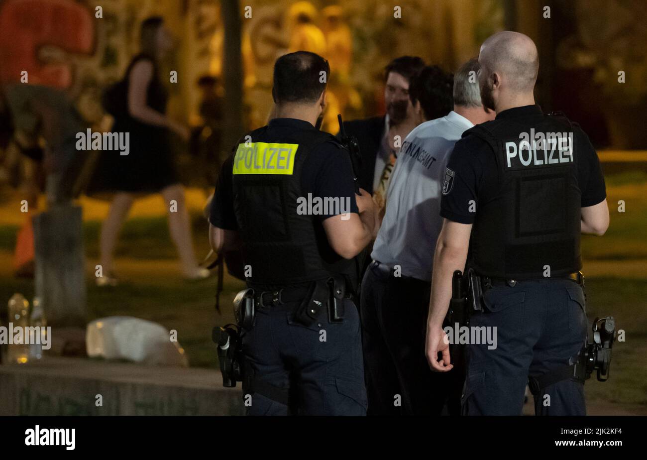 Berlin, Germany. 29th July, 2022. Employees of the Ordnungsamt Bezirk Mitte walk through James Simon Park with police officers. After riots, there is an alcohol ban there as well as in Monbijoupark from 10 p.m. to 6 a.m. Credit: Paul Zinken/dpa/Alamy Live News Stock Photo