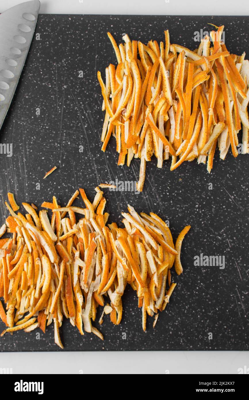 Orange rind thinly sliced, julienned orange rind on cutting board, orange skin Stock Photo