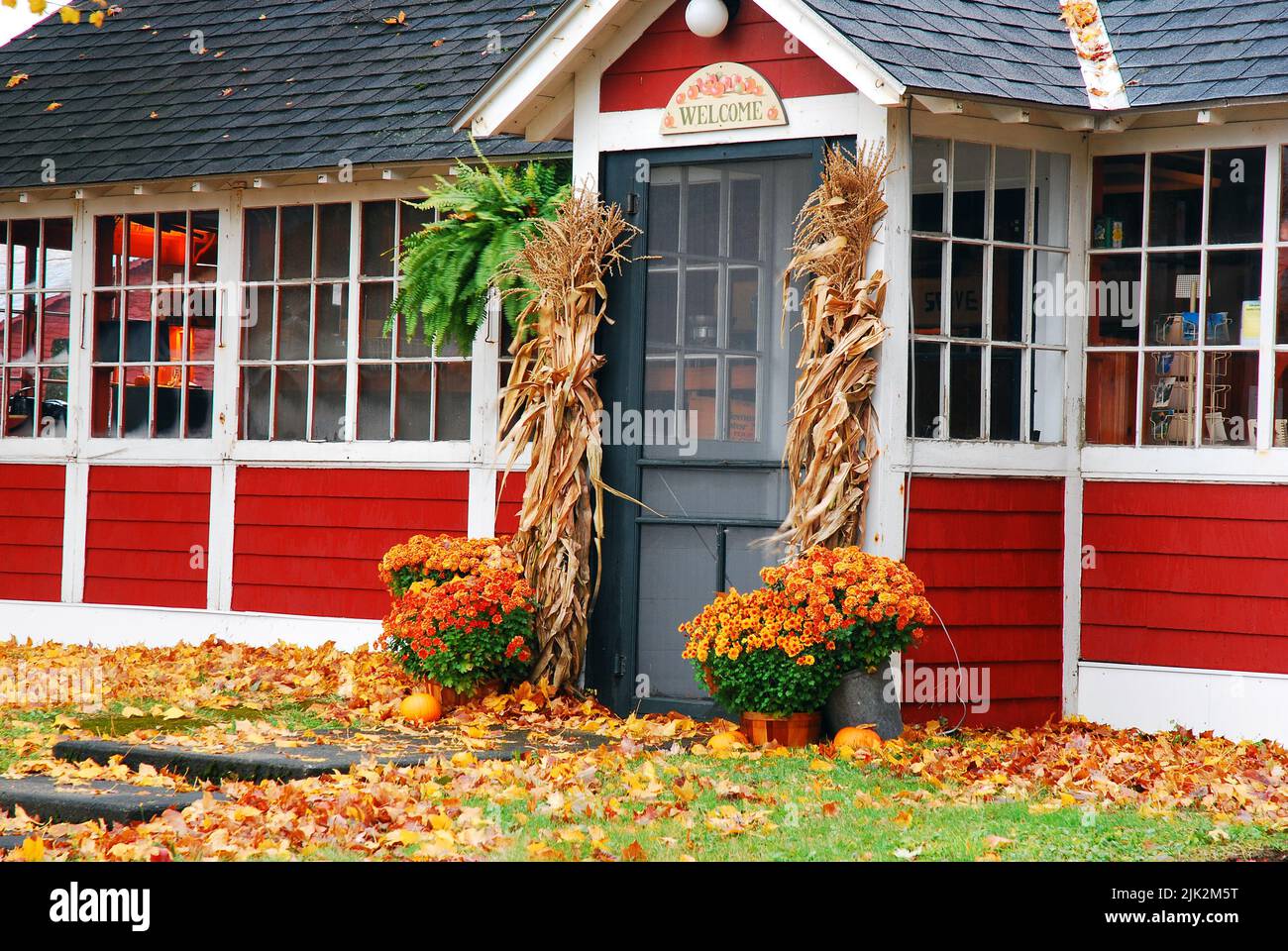 Fall decorations and fallen leaves are outside a cider mill and cafe in New England on an autumn day Stock Photo