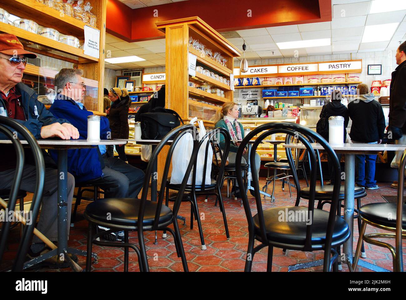 Senior men take a familiar seat at a pastry shop, specializing in canoli and other Italian snacks and desserts, in Boston’s North End Stock Photo