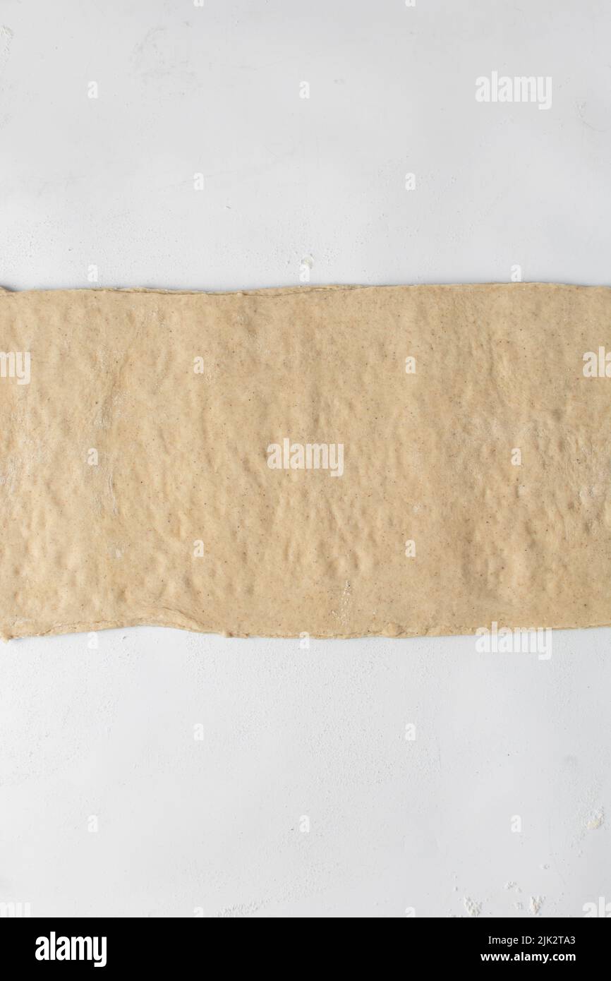 Pastry dough rolled out on a white background, stretched dough Stock Photo