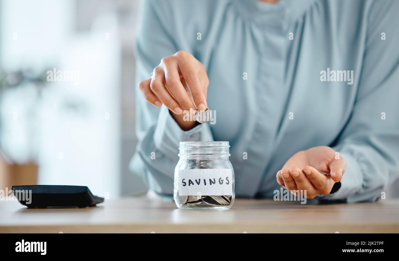 Savings, budget and economical woman putting coins in a jar at home. Closeup of woman calculating her expenses and saving money for future investment Stock Photo