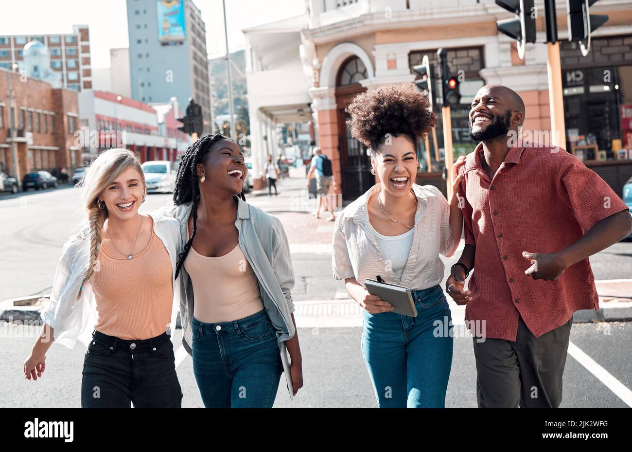 Happy, young and free trendy friends having fun on a day in the city, laughing while walking and talking together. Diverse group exploring downtown Stock Photo