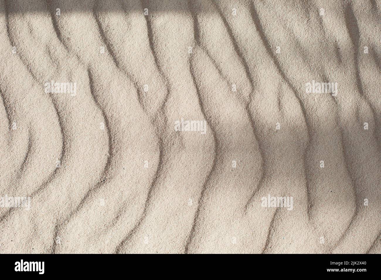 Coastal beach sand waves texture background. Sand dunes, tropical seashore landscape. Stock Photo