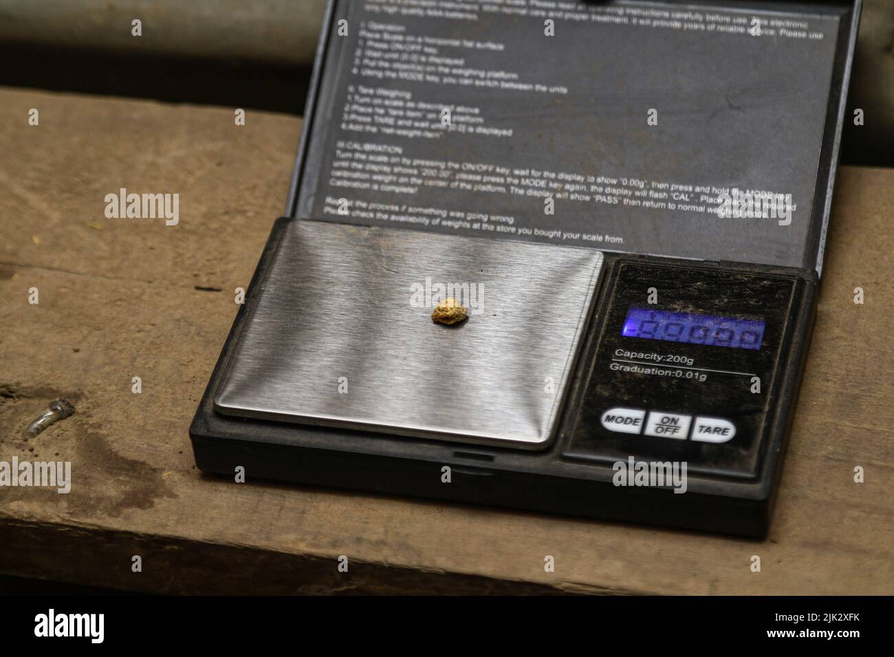 A small piece of processed gold is seen being weighed at a gold mining