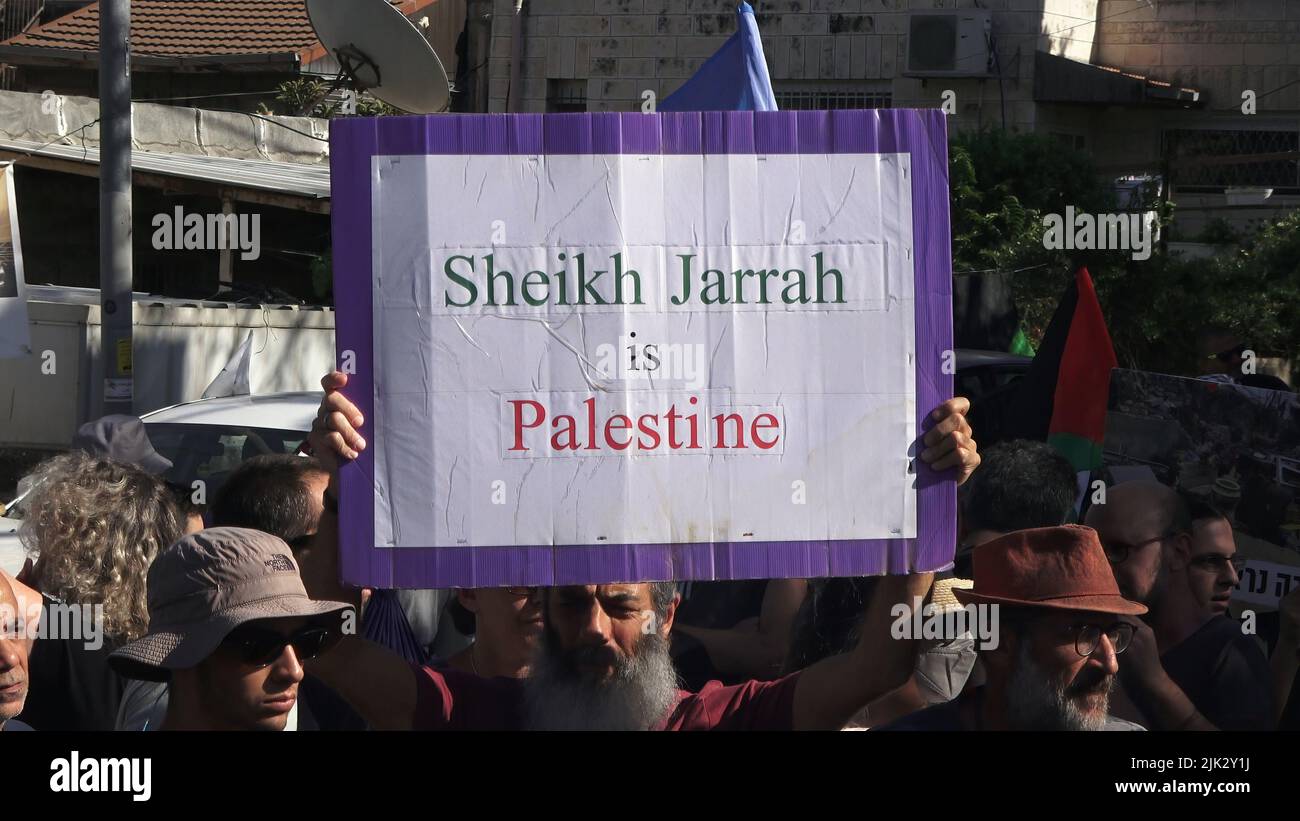 Jerusalem, Israel. 29th July, 2022. JERUSALEM, ISRAEL - JULY 29: An Israeli left-wing activist holds a sign which reads 'Sheikh Jarrah is Palestine' during a demonstration against Israeli occupation and settlement activity in the Sheikh Jarrah neighborhood on July 29, 2022 in Jerusalem, Israel. The Palestinian neighborhood of Sheikh Jarrah is currently the center of a number of property disputes between Palestinians and right-wing Jewish Israelis. Some houses were occupied by Israeli settlers following a court ruling. Credit: Eddie Gerald/Alamy Live News Stock Photo