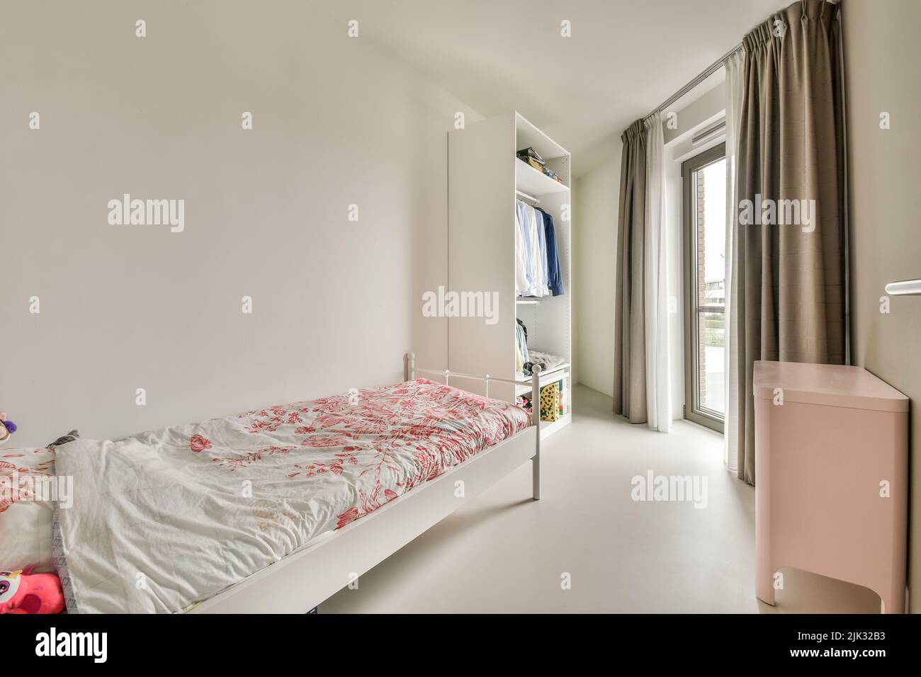 Interior of modern kid bedroom with bed and shelves with various toys at home Stock Photo