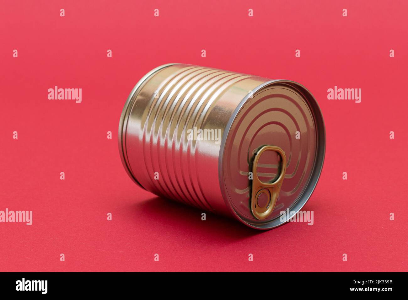 Unopened Tin Can with Blank Edge on Red Background. Canned Food