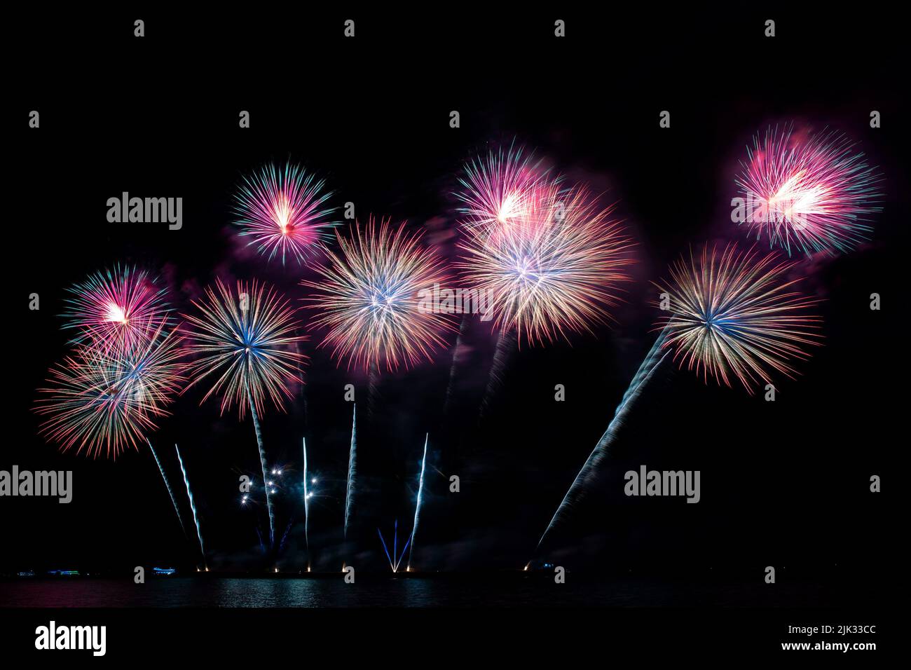 Festive beautiful colorful fireworks display on the sea beach, Amazing holiday fireworks party or any celebration event in the dark sky Stock Photo
