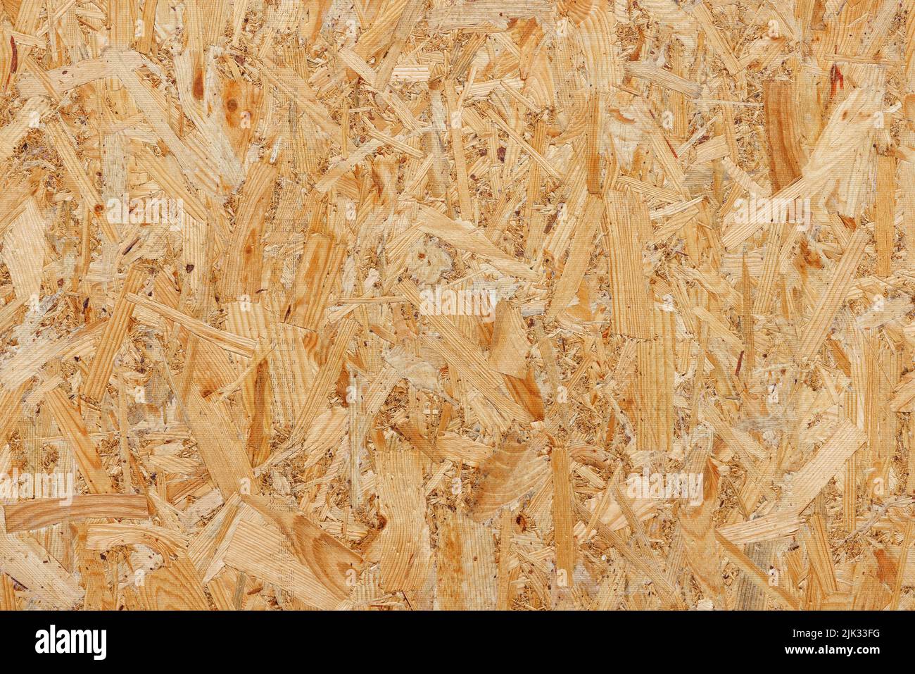 OSB, board texture and background of pressed sandy brown particle board, closeup. Stock Photo