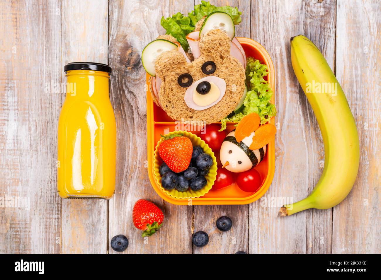 Kids lunch box with funny bear sandwich and boiled egg bee, banana
