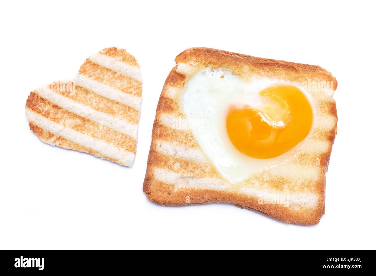 Heart shaped fried eggs in a Toasted bread with grill marks isolated on