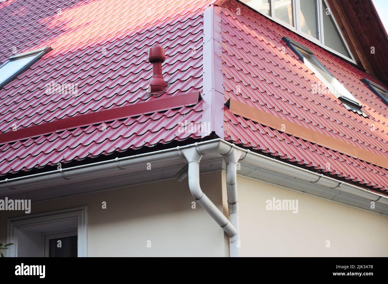 A closeup of a metal roof corner problem area with a roof gutter