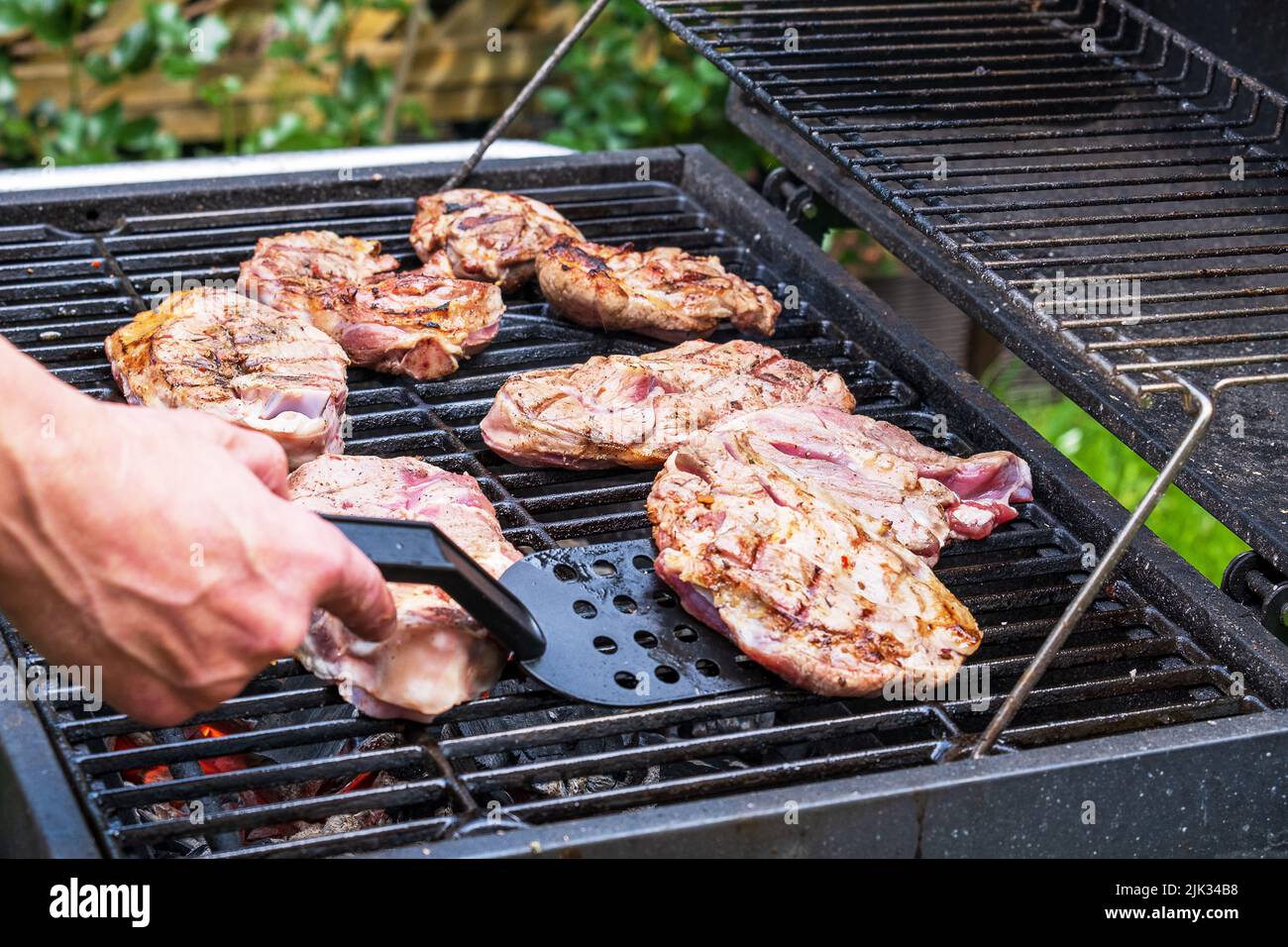 Pieces of fresh raw meat laid out on grill grate. Stock Photo