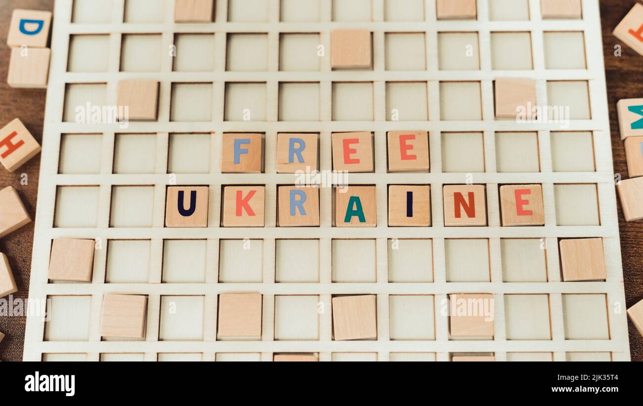 Free Ukraine. No more war concept. Wooden square puzzles with colourful letters with a strong anti-war message. High quality photo Stock Photo