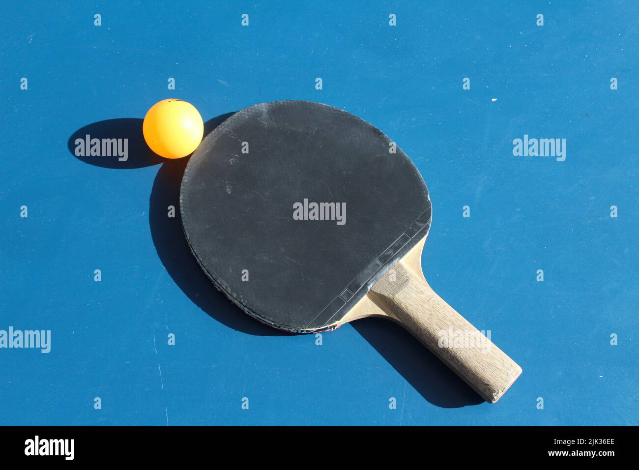 Ping pong or table tennis paddle, ping pong paddle and ball isoleted on blue background. Top view, horizontal photo. Copy space. No people, nobody. Stock Photo