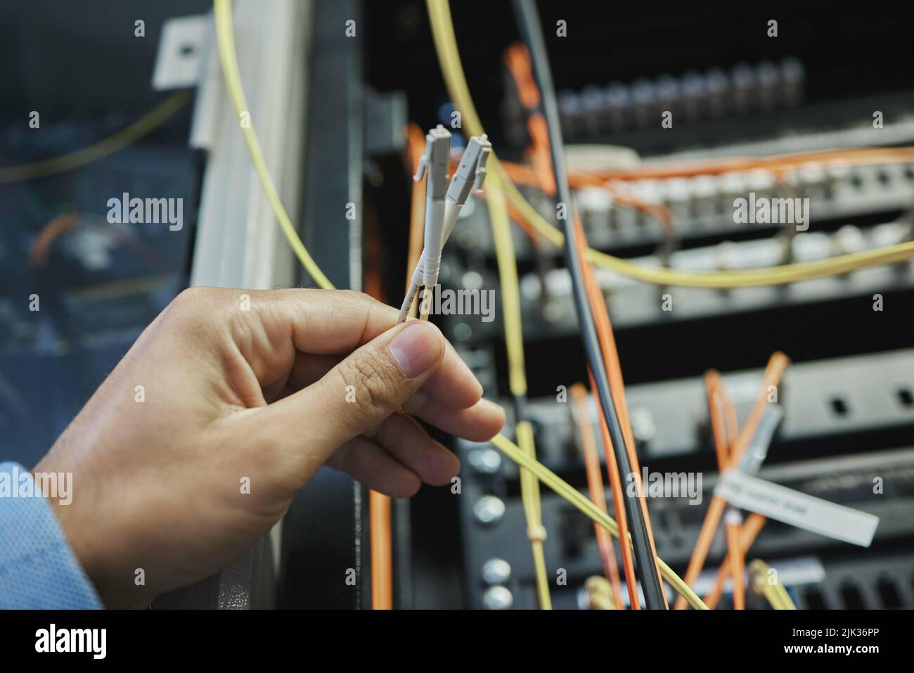 Same skills as a surgeon, different scalpels. an unrecognizable woman working on cables in a server room. Stock Photo